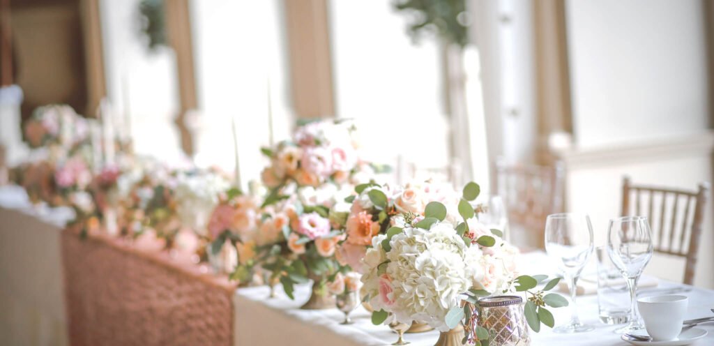 Elegant wedding table adorned with lush floral arrangements and delicate greenery, creating a romantic and sophisticated ambiance