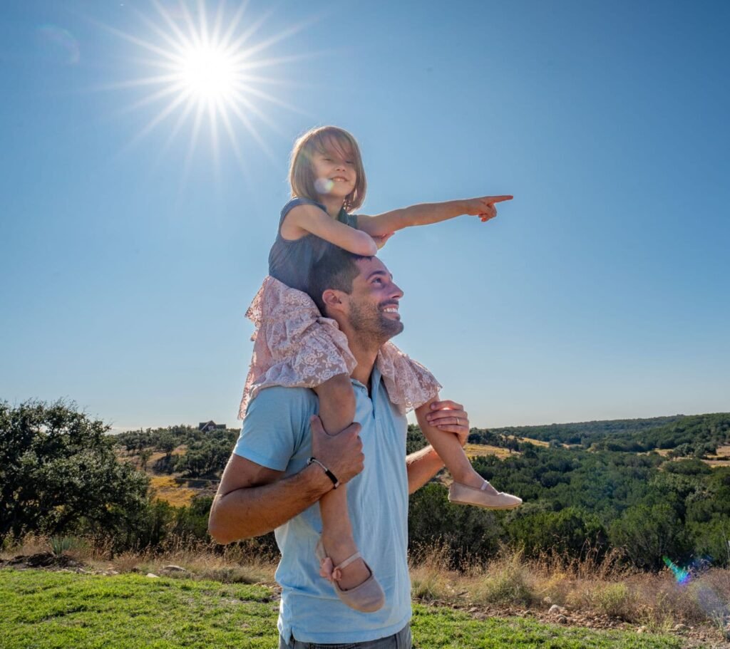 Dad with daughter on his shoulders spotting wildlife on an adventure tour at the ranch