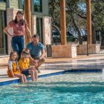 family swimming in luxury pool at Artemis Lodge