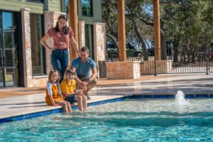 family swimming in luxury pool at Artemis Lodge